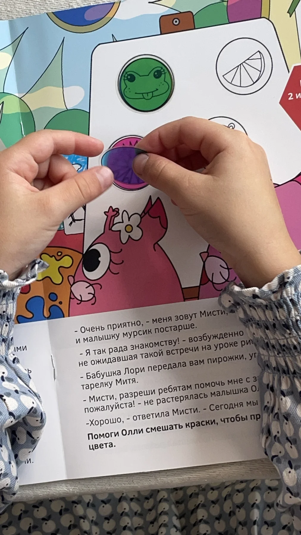 Ребёнок приклеивает наклейку в книгу