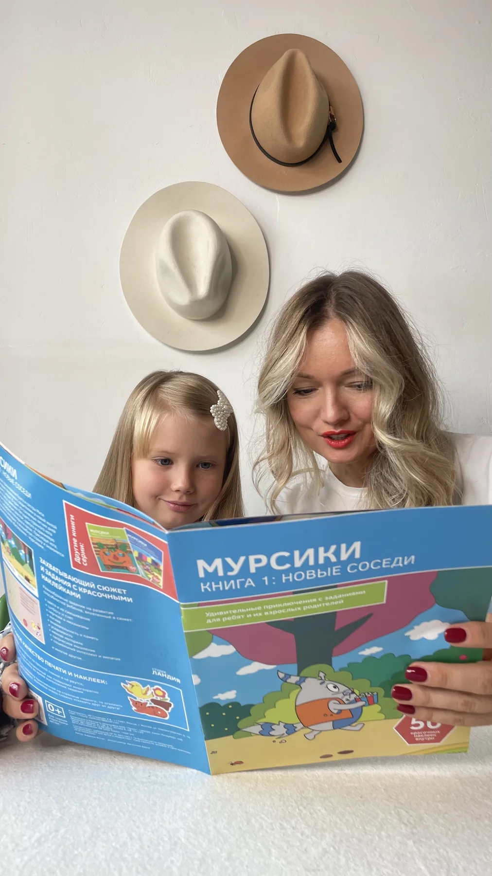 Мама и дочь вместе читают книгу о Мурсиках